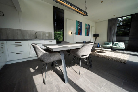 Moderne inrichting van de L-Cube lodge in Spaarnwoude, Nederland, met eettafel en zithoek in beeld.