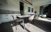 Moderne inrichting van de L-Cube lodge in Spaarnwoude, Nederland, met eettafel en zithoek in beeld.