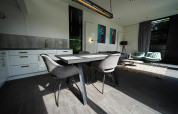 Moderne inrichting van de L-Cube lodge in Spaarnwoude, Nederland, met eettafel en zithoek in beeld.