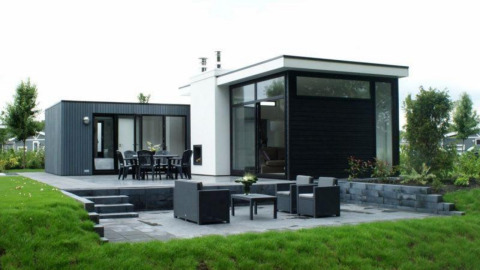 Lodge moderne L-Cube à Spaarnwoude, Pays-Bas, avec terrasse, grandes fenêtres et vue sur le jardin.