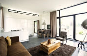 Moderne lodge Cube Maximaal in Spaarnwoude, Nederland met open woonruimte, keuken en grote raampartijen.
