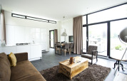 Moderne lodge Cube Maximaal i Spaarnwoude, Holland med åben stue, køkken og store vinduer til terrassen.