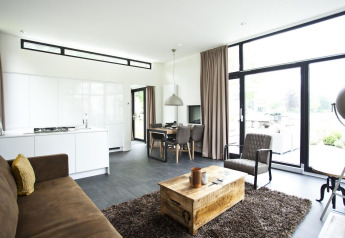 Moderne Lodge Cube Maximaal in Spaarnwoude, Niederlande, mit hellem Wohnraum und großen Fenstern zur Terrasse.