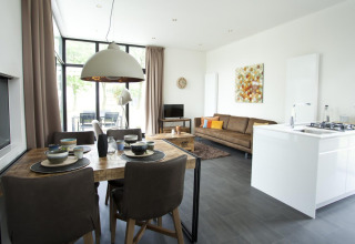 Moderne inrichting van Cube Maximaal lodge in Spaarnwoude, Nederland, met woon-, eet- en keukenruimte.