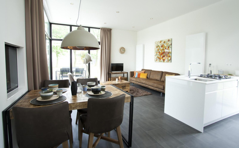 Interior moderno en la cabaña Cube Maximaal en Spaarnwoude, Países Bajos, con sala, comedor y cocina.