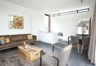 Moderne lodge Cube Maximaal in Spaarnwoude, Nederland, met woonkamer, open keuken en eethoek.