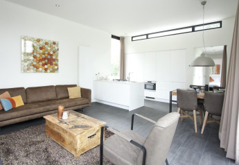 Moderne lodge Cube Maximaal i Spaarnwoude, Holland, med stue, åbent køkken og spiseplads.