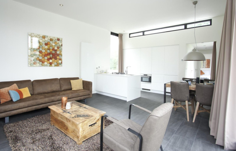 Interior moderno de la lodge Cube Maximaal en Spaarnwoude, Países Bajos, con sala, cocina y comedor.