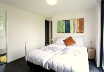 Dormitorio luminoso en la cabaña Cube Maximaal en Spaarnwoude, Países Bajos, con cama doble y decoración moderna.