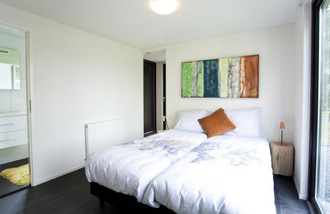 Dormitorio luminoso en la cabaña Cube Maximaal en Spaarnwoude, Países Bajos, con cama doble y decoración moderna.