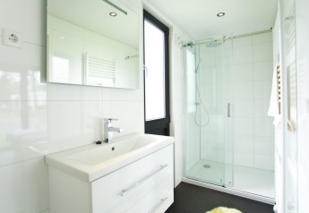 Bagno moderno nella lodge Cube Maximaal a Spaarnwoude, Paesi Bassi, con doccia e grande specchio.