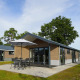 Moderne lodge ved Velthorst på Zilverstrand, Belgien, med have, terrasse og udendørs bord med parasol.