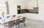 Cuisine moderne et salle à manger d'une lodge Velthorst à De Wije Werelt, Pays-Bas, avec table dressée.