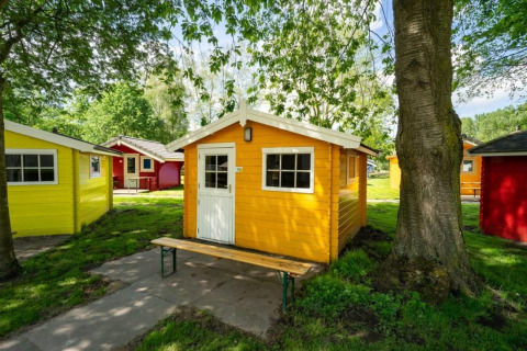 Cabañas de madera coloridas en Cabin at Het Amsterdamse Bos, rodeadas de árboles, en los Países Bajos.