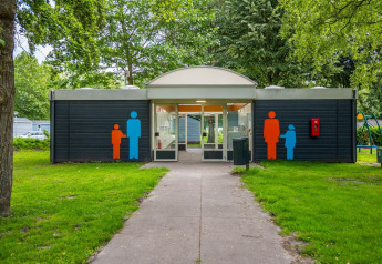 Entrada a un baño público en Cabin at Het Amsterdamse Bos, con símbolos de hombre y mujer afuera.
