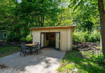 Lille træhytte med åbne døre og terrasse i skoven ved Forest Lodge, Het Amsterdamse Bos, Holland.