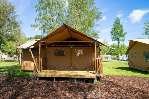 Safari-Glampingzelt im Het Amsterdamse Bos, Niederlande, auf einer grünen, offenen Campingfläche.