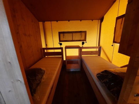 Innenansicht eines Safari-Glampingtents mit zwei Einzelbetten in Het Amsterdamse Bos, Niederlande.