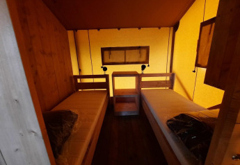 Vue intérieure d'une tente safari Glampingtent avec deux lits simples à Het Amsterdamse Bos, Pays-Bas.