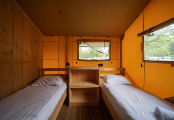 Intérieur d'une tente de glamping confortable avec deux lits simples à Het Amsterdamse Bos, Pays-Bas.