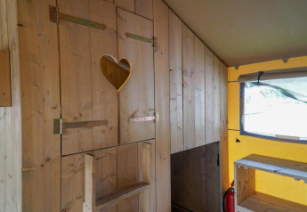 Interior view of a wooden glamping tent with a heart-shaped cutout at Het Amsterdamse Bos in the Netherlands.
