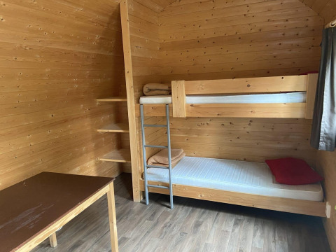 Interior de una pequeña casa de madera con litera, estanterías y escritorio en Het Amsterdamse Bos, Países Bajos.