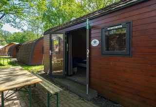 Exterior de la tiny house Pod en Het Amsterdamse Bos, Países Bajos, con naturaleza y mesa de picnic.