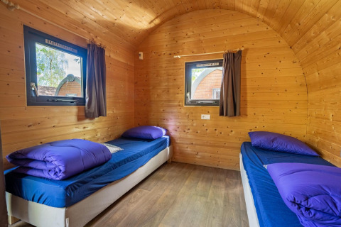 Interior de una pequeña casa de madera, Pod, con dos camas individuales en Het Amsterdamse Bos, Países Bajos.