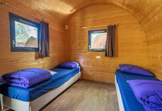Interior de una pequeña casa de madera, Pod, con dos camas individuales en Het Amsterdamse Bos, Países Bajos.