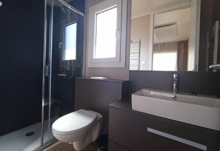 Modern badkamer in tiny house met zwevend toilet, inloopdouche en vierkante wastafel bij Maastricht.