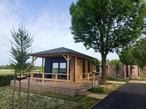 Moderne tiny house ved Poort van Maastricht i Holland omgivet af grønne træer og natur.