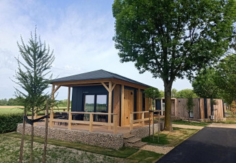 Moderne tiny house ved Poort van Maastricht i Holland omgivet af grønne træer og natur.
