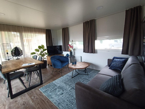 Soggiorno moderno in lodge Palisade a Poort van Maastricht, Olanda, con arredi accoglienti in legno.