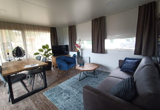 Soggiorno moderno in lodge Palisade a Poort van Maastricht, Olanda, con arredi accoglienti in legno.