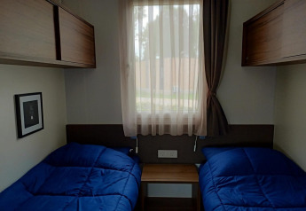 Gezellige kamer in Palisade bij Poort van Maastricht, Nederland, met twee enkele bedden en blauwe dekens.