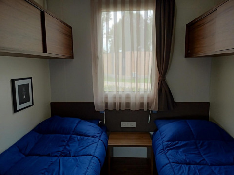 Gezellige kamer in Palisade bij Poort van Maastricht, Nederland, met twee enkele bedden en blauwe dekens.