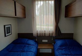 Chambre confortable au Palisade, Poort van Maastricht, Pays-Bas, avec deux lits simples à couettes bleues.