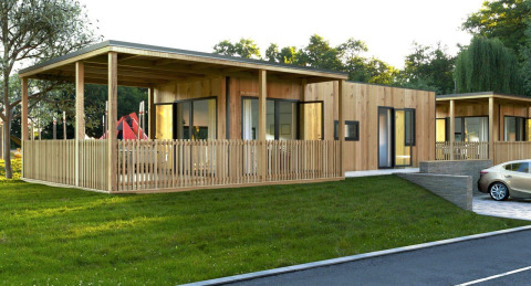 Moderne houten lodge bij Palisade aan Poort van Maastricht in Nederland, met terras en parkeerplaats.