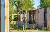 Outdoor view of Belsano lodge at Poort van Maastricht, Netherlands, with wooden exterior and terrace.