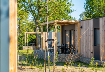 Vista esterna del lodge Belsano a Poort van Maastricht, Paesi Bassi, con terrazza e rivestimento in legno.