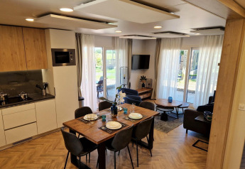 Moderna lodge Belsano a Poort van Maastricht nei Paesi Bassi, con cucina aperta, tavolo da pranzo e soggiorno luminoso.
