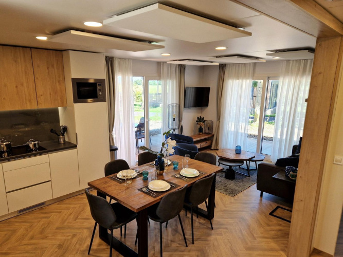Modern Belsano lodge at Poort van Maastricht, Netherlands with open kitchen, dining table, and bright living room.