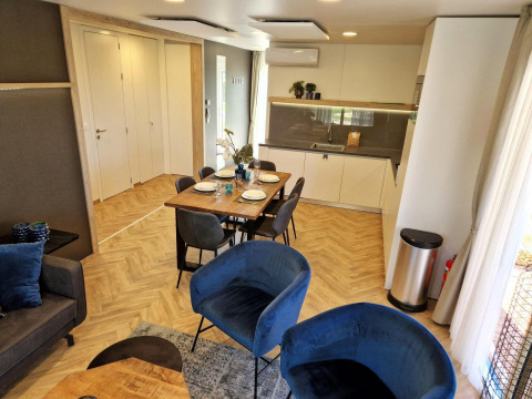 Moderne opholdsstue og køkken i Belsano-lodgen ved Poort van Maastricht, Nederlandene, med elegant indretning.