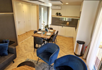 Soggiorno e cucina moderni nella lodge Belsano a Poort van Maastricht, Paesi Bassi, con arredi eleganti.