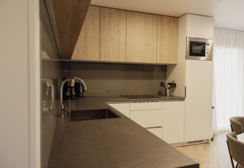 Moderne Küche in der Belsano-Lodge am Poort van Maastricht mit Holzschränken und elegantem Design.