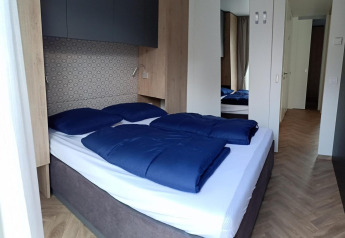 Camera moderna al Belsano, Poort van Maastricht, Paesi Bassi, con letto matrimoniale e biancheria blu.