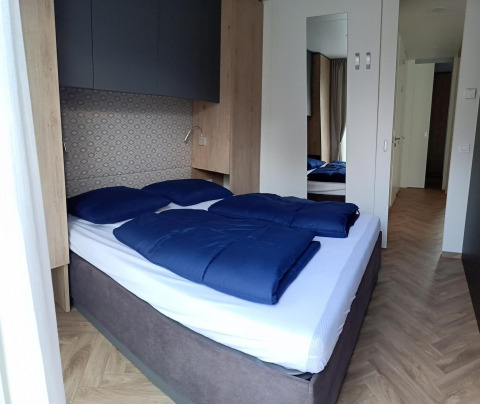 Dormitorio moderno en Belsano, Poort van Maastricht, Países Bajos, con cama doble y ropa de cama azul.