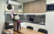 Modern kitchen lodge at Domus, Poort van Maastricht, Netherlands, featuring wood table and flower vases.