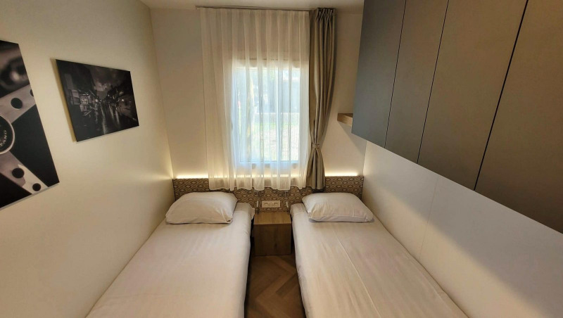 Habitación doble luminosa en el lodge Domus, Poort van Maastricht, con dos camas individuales y decoración.