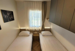 Habitación doble luminosa en el lodge Domus, Poort van Maastricht, con dos camas individuales y decoración.